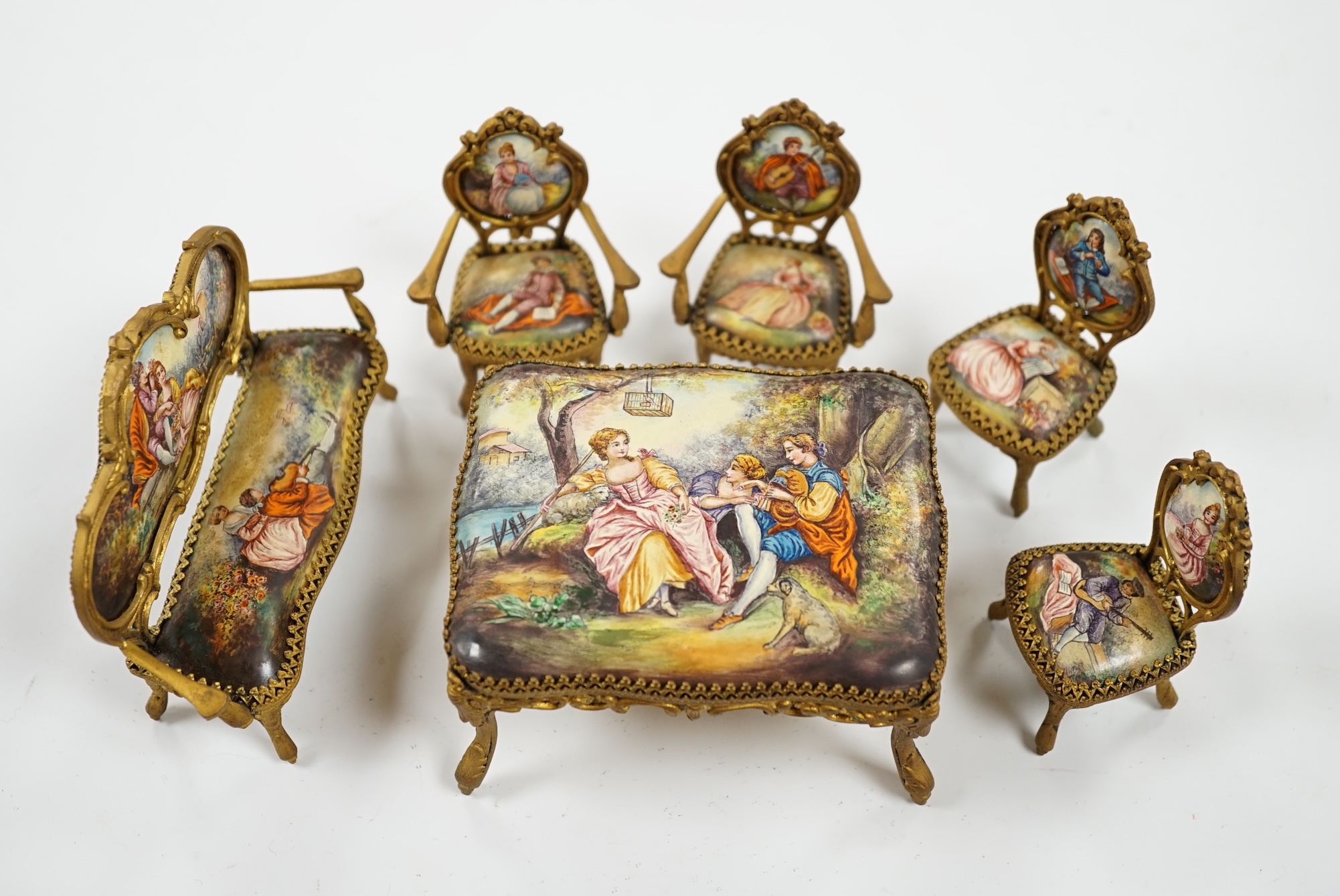 An early 20th century miniature enamel and gilt metal framed furniture set, possibly Austrian, largest 9cm wide. Condition - fair